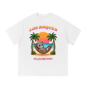 Los Roques tee in white, front view with sunset beach scene, PlushBerry bear in a hammock between palm trees and PLUSHBERRY wordmark