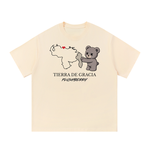Tierra de Gracia tee in apricot, front view with Venezuela map including hatched Guayana Esequiba, Caracas heart, PlushBerry bear and PLUSHBERRY wordmark